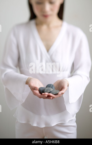 Junge Frau Holding Steinen Stockfoto