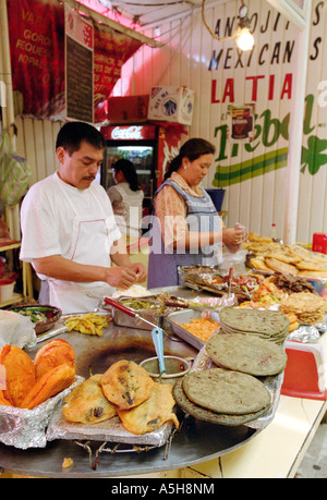 Mann und Frau verkaufen lokale Spezialitäten und Fast-Food-Snacks in einem Stall in Mercardo Merced (Markt), Mexiko-Stadt. Stockfoto