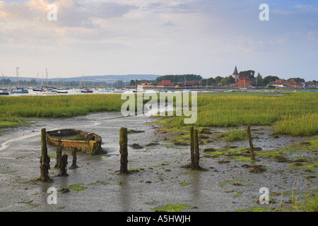 Reste der alten Bootssteg und ein Ruderboot Wrack mit Bosham Hafen im Hintergrund England UK Stockfoto