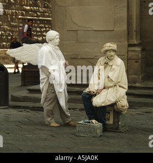 Italienische Candid Street Szene zwei Pantomimen, unterhaltsame Touristen mit Zigarette in der Hand & Angel Wings Florenz Toskana Italien Stockfoto