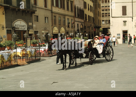 Italienische Pferdekutschen offener Laufwagen zwei Frauen Passagiere am Bürgersteig Bars & Restaurants in Piazza della Signoria Florenz Toskana Italien EU anreisen Stockfoto