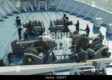 Bogen der Kreuzfahrt Schiff Besatzungsmitglieder Führung heavy-Duty Festmacher Seile beim Andocken Verfahren Stockfoto