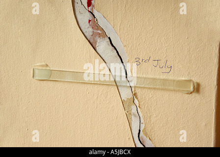 Haus innen Schäden an Wand mit Glasleiste geklebt über Riss durch die Versicherungsgesellschaft, weitere Bewegung zu überwachen Stockfoto