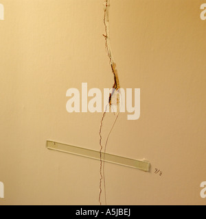 Haus innen Schäden an Wand mit Glasleiste geklebt über Riss durch die Versicherungsgesellschaft, weitere Bewegung zu überwachen Stockfoto