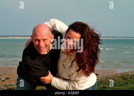 Herr Liebhaber zu Fuß in der Seeküste in freudiger Umarmung Stockfoto