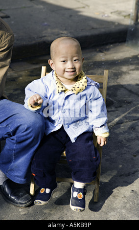 CHINA SHANGHAI liebenswert chinesischen jungen Kleinkind sitzt neben seinem Vater auf dem Markt im alten Shanghai Stockfoto