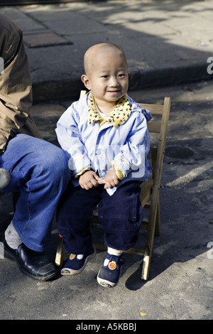 CHINA SHANGHAI liebenswert chinesischen jungen Kleinkind sitzt neben seinem Vater auf dem Markt im alten Shanghai Stockfoto