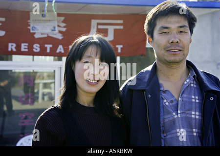 CHINA SIMITAI attraktive junge chinesische mongolische paar vor ihrer Familie stehen im Besitz restaurant Stockfoto