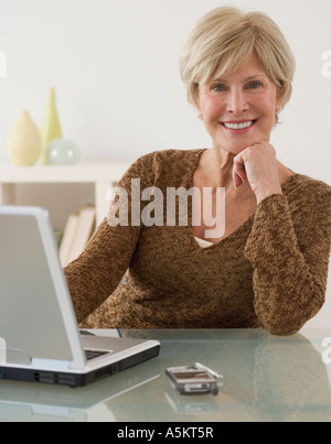 Porträt von senior Frau neben laptop Stockfoto