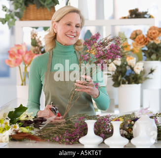 Weibliche Florist schneiden Blumen Stockfoto