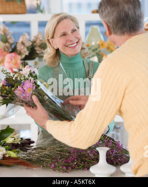 Weibliche Florist helfen Kunden Stockfoto