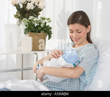 Mutter lächelte neugeborenes Baby im Krankenhaus Stockfoto