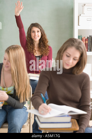 Studentin, hob die Hand im Klassenzimmer Stockfoto