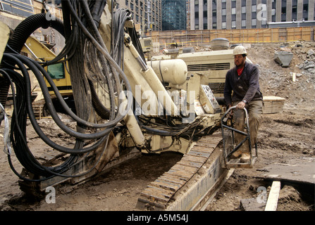 Bohrer-Operator mit modifizierten Bohrständer montiert auf einer Plattform Baggerlader. Stockfoto