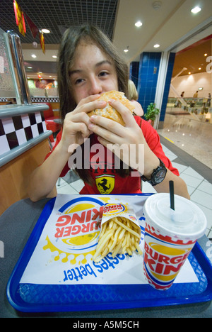 Teenager einen Burger King Hamburger Essen Stockfoto