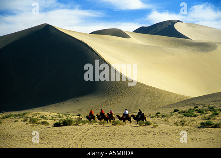 Dunhuang Singing Sands Berge Dünen mit Touristen auf Kamel-Karawane in Gansu Provinz China Stockfoto