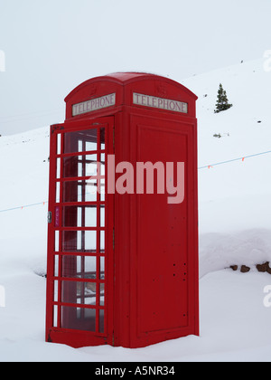 ROTE Telefonzelle K6 mit Tür öffnen in tief mitten im Winterschnee. Highland, Schottland, Vereinigtes Königreich Stockfoto