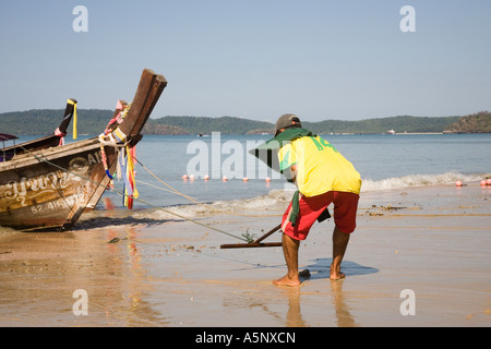 Schiffer heben Anker über Longtail Boot (เรือหางยาว) Krabi Provinz Beach Resort Thailand Stockfoto