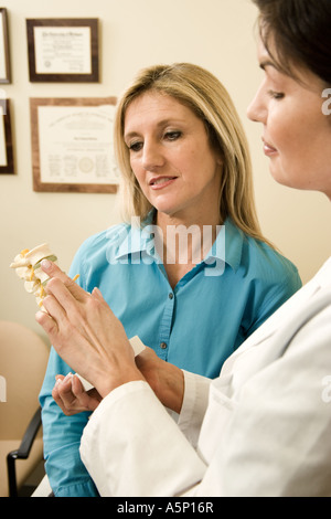 Medizinische Fachkraft lehrt Patientin über Osteoporose und der Wirbelsäule Gesundheit in einer Schmerzklinik. Stockfoto