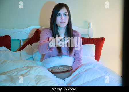 Frau sitzt im Bett Fernsehen. Stockfoto
