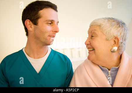 Krankenpfleger oder Krankenschwester oder Arzt Besuche bei weiblichen Patienten zu Hause oder in ein Pflegeheim Anlage kümmern. Stockfoto