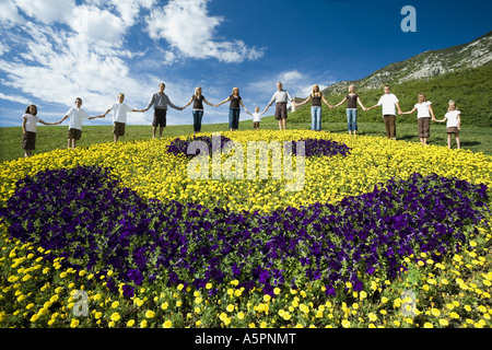 Großen Familiengruppe auf Hügel mit floralen glückliches Gesicht anzeigen Stockfoto