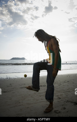 Profil eines Mannes spielen hacky Sack am Strand Stockfoto