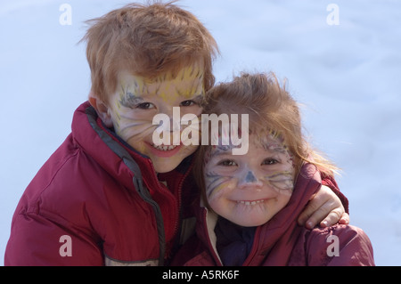 Herr zwei Kinder mit aufgemalten Gesichtern als Katzen für Karneval Stockfoto