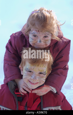 Herr zwei Kinder mit aufgemalten Gesichtern als Katzen für Karneval Stockfoto