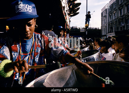 NOTTING HILL CARNIVAL LONDON AUGUST MENSCHENMASSEN BEOBACHTEN STAHL-BAND SPIELT AUF DER RÜCKSEITE EINES LKW AUF DER STRECKE VON DER STRAßE Stockfoto