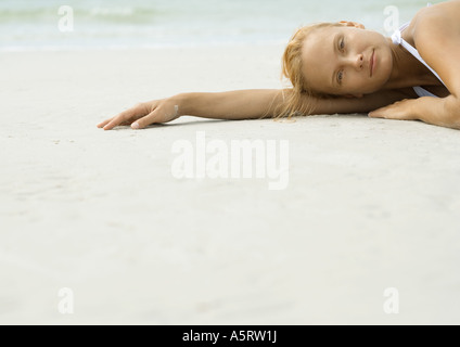 Frau liegt am Strand, Blick in die Kamera Stockfoto