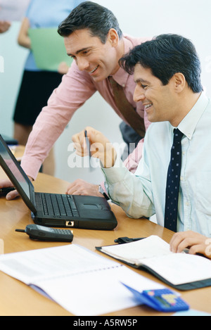 Geschäftskollegen mit Laptop zusammen, Lächeln Stockfoto
