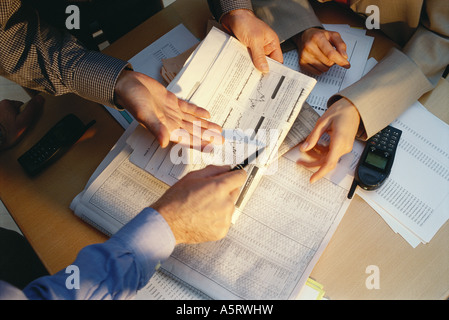 Geschäftsleute, gestikulieren, über Tisch, Finanzseiten von Zeitung, verkürzte Ansicht Stockfoto