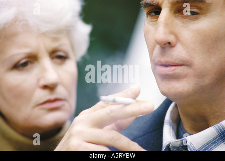 Senior woman Rauchen, Frau beobachtete ihn Stockfoto