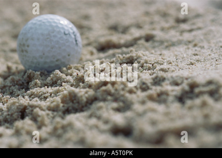 Golfball in Sand, Nahaufnahme Stockfoto