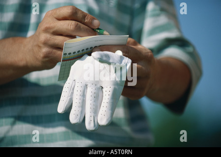 Golfer, die Partitur, close-up der Hände in Anbetracht Stockfoto