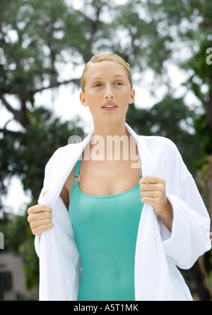 Junge Frau Bademantel über nassen Badeanzug anziehen Stockfoto