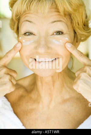 Ältere Frau Feuchtigkeitscreme unter den Augen auftragen Stockfoto