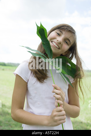 Mädchen halten Cassava Blatt Stockfoto