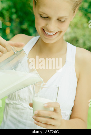 Frau Gießen Glas Milch Stockfoto