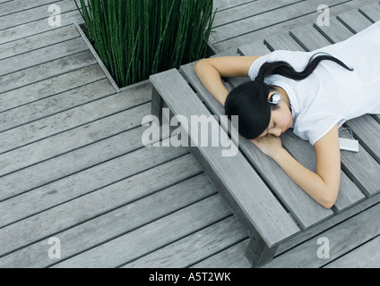 Frau liegend auf Liegestuhl Kopfhörer anhören Stockfoto