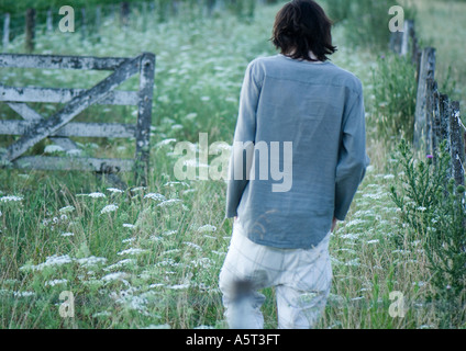 Mann zu Fuß in Feld, Rückansicht Stockfoto