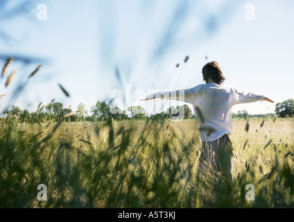 Mann, der im Feld mit Armen Stockfoto