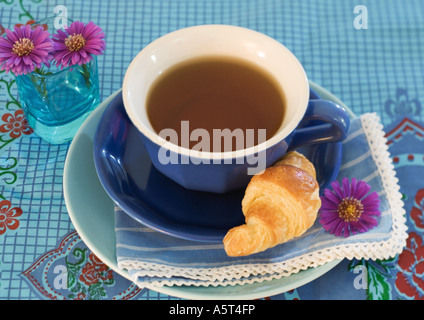 Tasse mit Untertasse und croissant Stockfoto