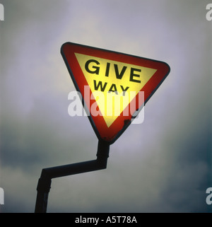 A Verkehrszeichen "Vorfahrt" Warnung vor einem dunklen grauen Himmel UK KATHY DEWITT beleuchtet Stockfoto