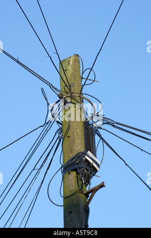 Telegrafenmast mit einer Reihe von Drähten verbunden Satz vor blauem Himmel Stockfoto