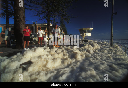 Kinder spielen im Meer Schaum Maroochydore Strand nach Sturm 3361 Stockfoto