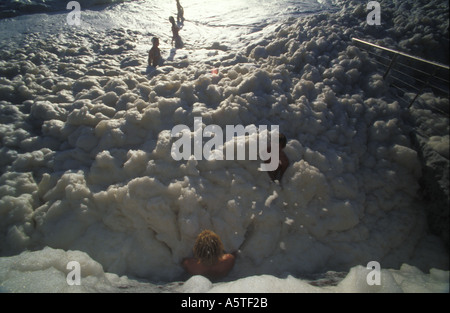 Kinder spielen im Meer Schaum Maroochydore Strand nach Sturm 3363 Stockfoto