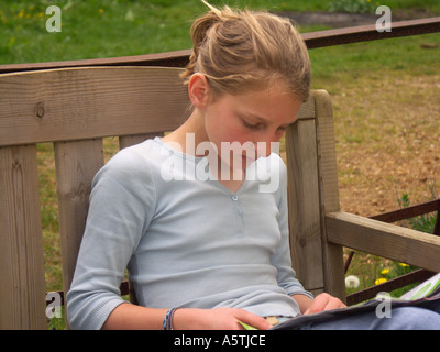 Elf Jahre altes Mädchen Lesen einer Zeitschrift Stockfoto