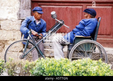 zwei ältere Männer gekleidet in traditionellen blau mit einem Gespräch in Lijiang Yunnan Provinz China. Stockfoto